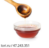 Наливание вкусного кленового сиропа из ложки в миску на белом фоне, крупным планом. Стоковое фото, фотограф Pixel_shot / Фотобанк Лори