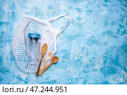 Сетчатый мешок с деревянными столовыми приборами и бутылкой для воды на цветном фоне. Концепция экологии. Стоковое фото, фотограф Pixel_shot / Фотобанк Лори