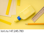 Бутылка клея, карандаш и линейка на желтом фоне. Стоковое фото, фотограф Pixel_shot / Фотобанк Лори