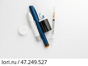 Ланцетные ручки, шприц и тест-полоски для глюкометра на белом фоне. Концепция диабета. Стоковое фото, фотограф Pixel_shot / Фотобанк Лори