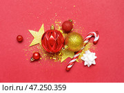 Композиция с красивыми елочными украшениями и пайетками на красном фоне. Стоковое фото, фотограф Pixel_shot / Фотобанк Лори