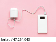 Современный внешний аккумулятор и чехол для наушников на розовом фоне. Стоковое фото, фотограф Pixel_shot / Фотобанк Лори