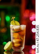 Стакан вкусного коктейля Cuba Libre на столе на фоне размытого света. Стоковое фото, фотограф Pixel_shot / Фотобанк Лори