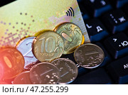 Кредитная карта и рублевые монеты на клавиатуре компьютера. Редакционное фото, фотограф E. O. / Фотобанк Лори