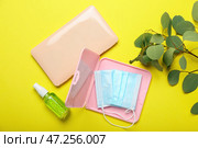 Медицинская маска с чехлами и дезинфицирующим средством на желтом фоне. Стоковое фото, фотограф Pixel_shot / Фотобанк Лори