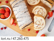 Разделочная доска с вкусным бисквитным рулетом и свежими ягодами на светлом столе. Стоковое фото, фотограф Pixel_shot / Фотобанк Лори