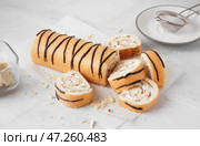Вкусный бисквитный рулет и тарелка с сахарной пудрой на белом столе. Стоковое фото, фотограф Pixel_shot / Фотобанк Лори