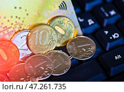 Кредитная карточка и рублевые монеты на клавиатуре компьютера. Редакционное фото, фотограф E. O. / Фотобанк Лори