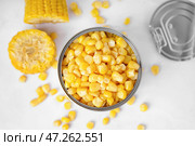 Жестяная банка с кукурузными зернами и початками на белом столе. Стоковое фото, фотограф Pixel_shot / Фотобанк Лори