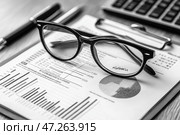Close up of business workplace with financial reports and eyeglasses. Accounting. Крупный план рабочего места бизнесмена с финансовыми отчетами и очками. Бухгалтерия. Стоковое AI-изображение, AI-художник Katsiaryna Repich / Фотобанк Лори