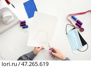 Портной-женщина в мастерской шьет защитные маски. Стоковое фото, фотограф Pixel_shot / Фотобанк Лори