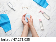 Руки с мылом, дезинфицирующими средствами и медицинскими масками на светлом фоне. Стоковое фото, фотограф Pixel_shot / Фотобанк Лори