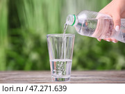 Налив воды в стакан на столе на открытом воздухе. Стоковое фото, фотограф Pixel_shot / Фотобанк Лори