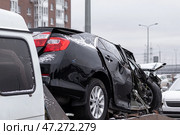 A completely wrecked car on a tow truck covered in snow. Стоковое фото, фотограф Михаил Яковлев / Фотобанк Лори