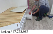 The man installs a linen drawer into the sofa bed. He attaches a handle to the drawer. Self-assembly of furniture. Стоковое видео, видеограф Vadzim Yakubovich / Фотобанк Лори