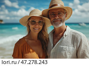 Couple of people standing on the beach enjoying the nice weather. Man with greying hair and beard wearing light white shirt and straw hat. Woman with long blond hair wearing orange dress also wearing hat and sunglasses. They are smiling against blue sky and ocean creating an atmosphere of relaxation and happiness. Стоковое AI-изображение, AI-художник Анна Кривицкая / Фотобанк Лори