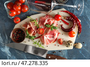 Композиция с вкусным хамоном, помидорами, специями и бокалом вина на цветном фоне. Стоковое фото, фотограф Pixel_shot / Фотобанк Лори