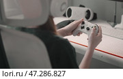 Young gamer immersed in gameplay, holding controller with high-tech computer setup. Close-up view highlights joystick, keyboard, and gaming accessories, showcasing virtual reality and technology. Стоковое видео, видеограф Енваев Андрей / Фотобанк Лори
