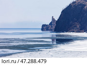 Baikal Lake in May. View from rocky shore of Olkhon Island to ice drift and to famous Cape Khoboy - natural landmark of lake Baikal. Beautiful spring landscape. Natural background. Changing seasons. Стоковое фото, фотограф Виктория Катьянова / Фотобанк Лори