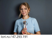 Creative Beauty Enthusiast Holding Makeup Brushes Against a Minimalist Backdrop. Стоковое фото, фотограф Aleksandr Golubev / Фотобанк Лори