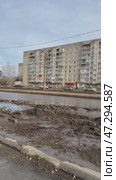 ANGARSK, IRKUTSK REGION, RUSSIA - March 20, 2025: Vertical video of spring cleaning of city roads. An excavator uses a bucket to clear the roadside of winter ice and mud. Редакционное видео, видеограф Виктория Катьянова / Фотобанк Лори
