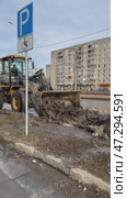 ANGARSK, IRKUTSK REGION, RUSSIA - March 20, 2025: Vertical video of spring cleaning of city roads. Road service workers use a backhoe loader to collect ice mud from the road. Редакционное видео, видеограф Виктория Катьянова / Фотобанк Лори