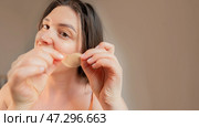 A woman enjoys beauty treatments at home, applying cooling hydrogel patches for a refreshed and glowing skin appearance. Стоковое фото, фотограф Svetlana Golovco / Фотобанк Лори