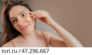 Relaxing beauty ritual: a woman applies cooling hydrogel eye patches, taking care of the delicate skin around her eyes. Стоковое фото, фотограф Svetlana Golovco / Фотобанк Лори