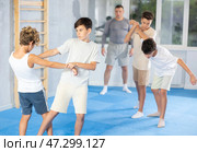 Teenage boys sparring in training room during self-defence workout. Стоковое фото, фотограф Яков Филимонов / Фотобанк Лори