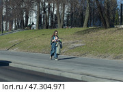 Москвичка ранней весной идет по тротуару на Севастопольском проспекте. Редакционное фото, фотограф Дмитрий Неумоин / Фотобанк Лори