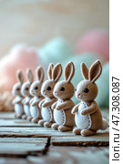 Crafty felt bunnies lined up in a warm setting perfect for spring celebrations and decorative displays. Стоковое AI-изображение, AI-художник Сергей Толмачёв / Фотобанк Лори