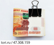 Пачка купюр 5000 рублей на канцелярском зажиме: самозапрет на кредиты, защита от мошенников, заначка. Стоковое фото, фотограф Ольга Дерябина / Фотобанк Лори