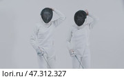 Fencing - two young women fencers in white suits putting on their protective helmets and stands in front of each other. Стоковое видео, видеограф Константин Шишкин / Фотобанк Лори