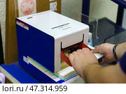 Osaka, Japan - Sep 22 2024, Close up view of the eki stamp, station stamping machine, at JR railway station, with a hands pressing the level, Osaka, Japan. Редакционное фото, фотограф Сергей Богомяко / Фотобанк Лори