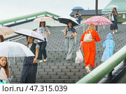 Osaka, Japan - Sep 22 2024, panoramic view of a lot of people with umbrellas going up and down the wide stairs to the Osaka JR ground station, on a rainy day, Osaka, Japan. Редакционное фото, фотограф Сергей Богомяко / Фотобанк Лори