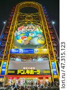 Osaka, Japan - Sep 22 2024, panoramic view from below of Don Quijote Dotonbori shopping and entertainment complex and Ferris wheel, in Dotonbori district, on canal corniche, at nighttime, Osaka, Japan. Редакционное фото, фотограф Сергей Богомяко / Фотобанк Лори