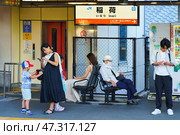 Kyoto, Japan - Sep 23 2024, panoramic view of the JR railway platform with passengers standing and sitting on it, waiting for a train, at daytime, Kyoto, Japan. Редакционное фото, фотограф Сергей Богомяко / Фотобанк Лори