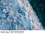 Winter aerial photograph of the icy coast and ice floes in sea water. Top view of the freezing sea. Nature of the Extreme North. Cold frosty winter weather. Harsh arctic climate. Natural background. Стоковое фото, фотограф Андрей Степанов / Фотобанк Лори