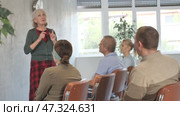 Friendly aged woman conducting language speaking club, communicating with group of interested older adults. Стоковое видео, видеограф Яков Филимонов / Фотобанк Лори