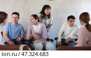 Group of cheerful carefree young students relaxing and chatting amicably during recess between lectures in auditorium. Стоковое видео, видеограф Яков Филимонов / Фотобанк Лори