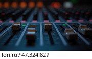 A detailed look at an audio mixing console, showcasing various faders in different positions. The setting highlights a professional sound environment. Стоковое AI-изображение, AI-художник Sergey Grishin / Фотобанк Лори