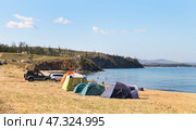 BAIKAL LAKE, OLKHON ISLAND, KHARANTSY VILLAGE, IRKUTSK REGION, RUSSIA - August 04, 2024:  Tourists set up tent camp on shore of Small Sea, swim, sunbathe, actively relax with their families on beach. Редакционное фото, фотограф Виктория Катьянова / Фотобанк Лори