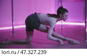 Young woman performing stretching exercises in pole dance studio. Стоковое видео, видеограф Константин Шишкин / Фотобанк Лори