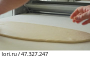 Dough being processed on a conveyor belt in a bakery making fresh flatbreads during daytime hours. Стоковое видео, видеограф Сергей Толмачёв / Фотобанк Лори