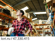 Thoughtful female storekeeper looking for tedious goods in building materials warehouse indoor. Стоковое фото, фотограф Яков Филимонов / Фотобанк Лори