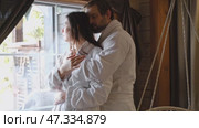 Mature couple in a white bathrobes hugging each other kissing at home room. Intimate Moment. Tender embrace shared between a loving middle age man and woman, husband and wife. Deep love. Vacation. Стоковое видео, видеограф Марина Демидюк / Фотобанк Лори