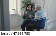 Old couple have breakfast sitting at the kitchen table, drink coffee. Embracing elderly man and woman. Senior couple together marriage in retirement talking with each other. Enjoying the pleasantries. Стоковое видео, видеограф Марина Демидюк / Фотобанк Лори