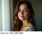 A young woman with flowing hair gazes softly out the window, enjoying the warm morning light. Her smile reflects a sense of calm and contentment in a cozy indoor setting. Стоковое AI-изображение, AI-художник Sergey Grishin / Фотобанк Лори