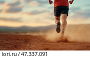 Runner enjoys evening jog in natural landscape at sunset. Бегун в красной футболке и шортах, совершающий пробежку по грунтовой дорожке, стремительно движется по живописной открытой площадке на закате. Под их ногами поднимается пыль, подчеркивая динамику движения. Стоковое AI-изображение, AI-художник Katsiaryna Repich / Фотобанк Лори