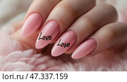Elegant pink nail design with love written on two nails. маникюр. Крупный план ухоженных рук с длинными острыми розовыми ногтями. На двух ногтях изящно выведено слово «любовь», придающее романтическую нотку. Стоковое AI-изображение, AI-художник Katsiaryna Repich / Фотобанк Лори